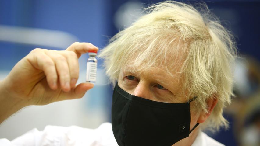 Großbritanniens Premierminister Boris Johnson hält ein  Fläschchen mit dem Corona-Impfstoff von Astrazeneca hoch. Um den in England entwickelten Impfstoff ist eine Debatte wegen seiner Nebenwirkungen entbrannt. Wissenschaftler und Politiker versichern, dass der Impfstoff sicher sei.