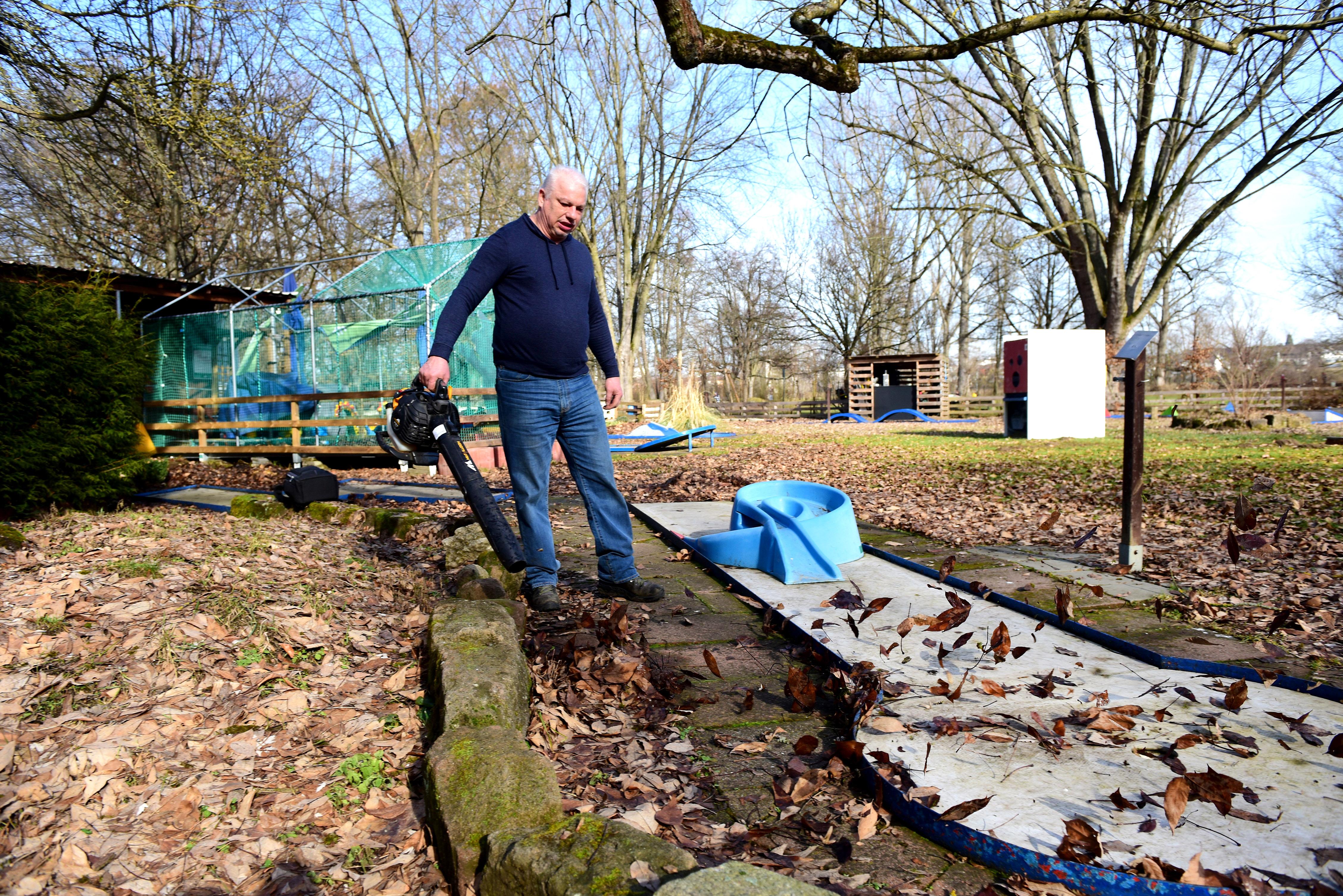 Norbert Burger befreite die Bahnen seiner Minigolfanlange schon mal vom alten Laub. Wann es wieder los geht, steht in den Sternen. Bis dahin begnügt er sich mit dem Kiosk-Betrieb.