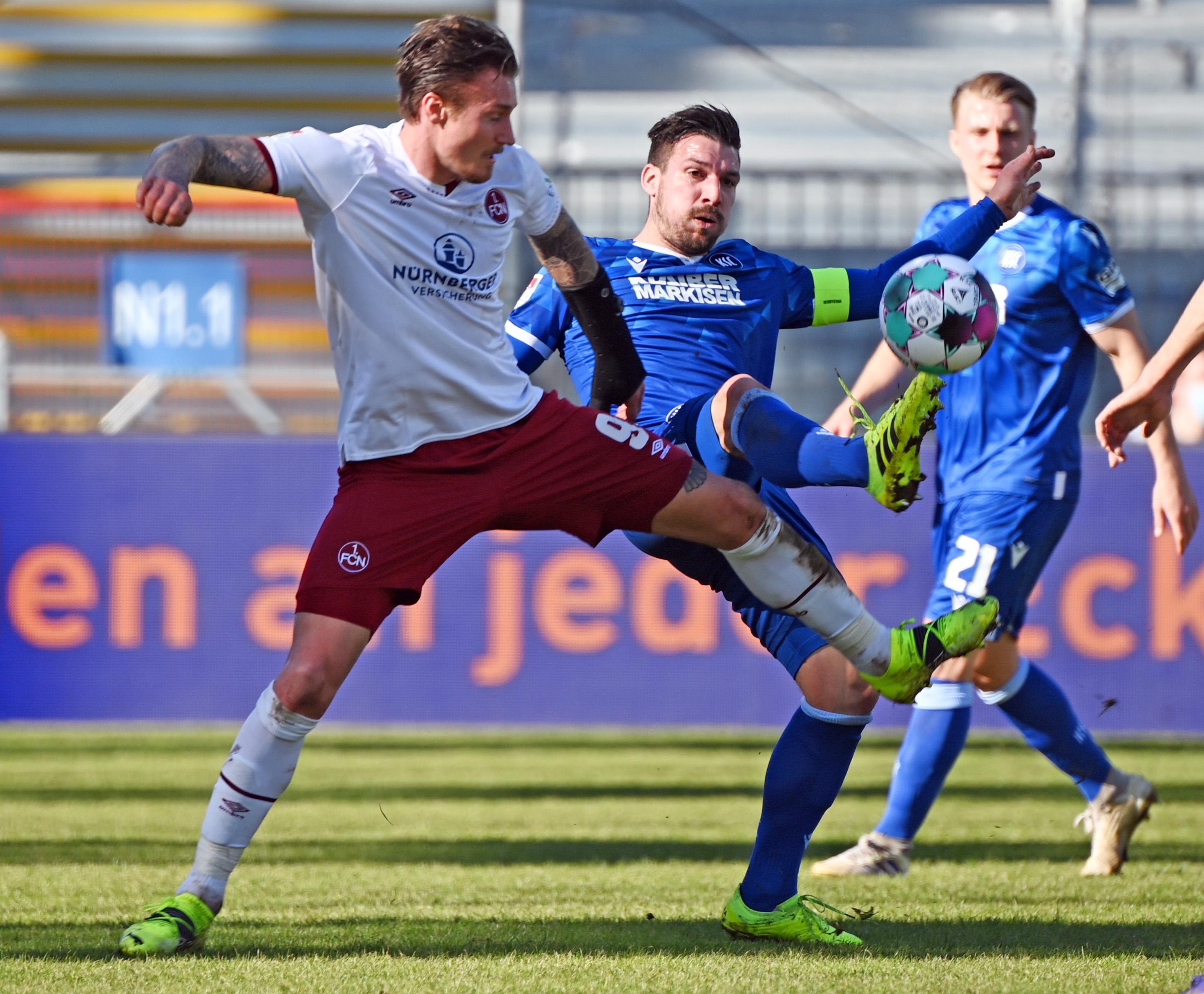 Der Club startet mit vier Änderungen in die Partie. Der Kapitän Enrico Valentini ist wieder fit, Georg Margreitter ersetzt Asger Sörensen in der Innenverteidigung. Im Sturm starten Manuel Schäffler und Dennis Borkowski als Doppelspitze. Damit und mit Fabian Nürnberger neben Johannes Geis auf der Doppel-Sechs hat Robert Klauß eine etwas offensivere Aufstellung gewählt. In den ersten Minuten geht für den FCN nach vorne aber trotzdem wenig, allerdings sieht es auch bei Karlsruhe nicht anders aus. Die Mannschaften tasten sich erst einmal ab und versuchen mit weiten Bällen in die gegnerische Hälfte zu kommen.
