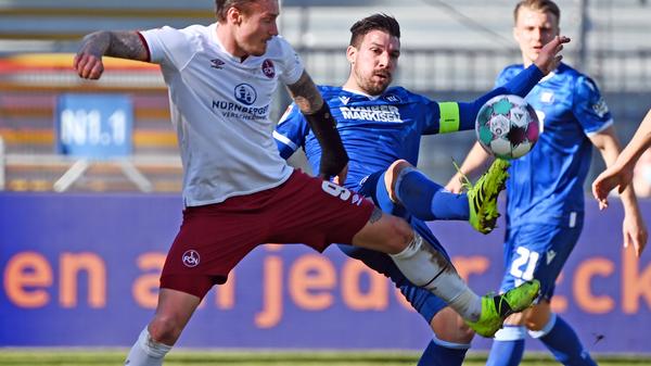 Der Club startet mit vier Änderungen in die Partie. Der Kapitän Enrico Valentini ist wieder fit, Georg Margreitter ersetzt Asger Sörensen in der Innenverteidigung. Im Sturm starten Manuel Schäffler und Dennis Borkowski als Doppelspitze. Damit und mit Fabian Nürnberger neben Johannes Geis auf der Doppel-Sechs hat Robert Klauß eine etwas offensivere Aufstellung gewählt. In den ersten Minuten geht für den FCN nach vorne aber trotzdem wenig, allerdings sieht es auch bei Karlsruhe nicht anders aus. Die Mannschaften tasten sich erst einmal ab und versuchen mit weiten Bällen in die gegnerische Hälfte zu kommen.