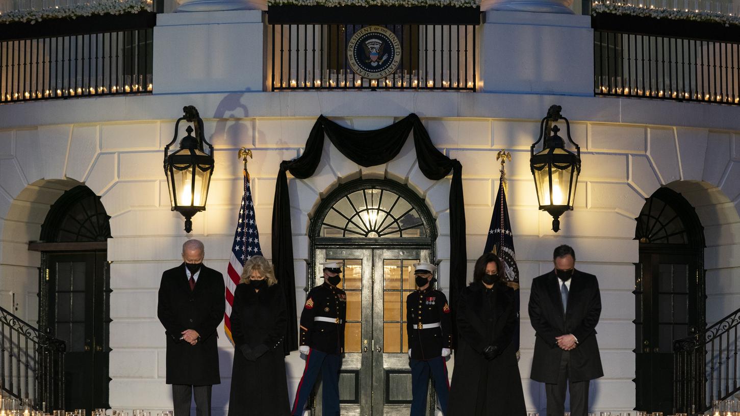 US-Präsident Joe Biden (l-r) mit seiner Frau First Lady Jill Biden und Vizepräsidentin Kamala Harris mit ihrem Mann Douglas Emhoff gedenken mit einer Schweigeminute vor dem Weißen Haus den Opfern der Pandemie. 
