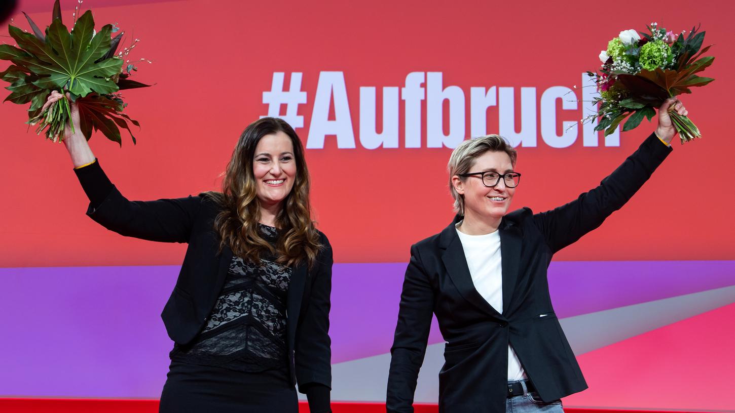 Janine Wissler (links) und Susanne Hennig-Wellsow (rechts), die neuen Bundesvorsitzenden der Partei Die Linke, stehen nach ihrer Wahl beim Online-Bundesparteitag der Linken zusammen und halten einen Blumenstrauß.