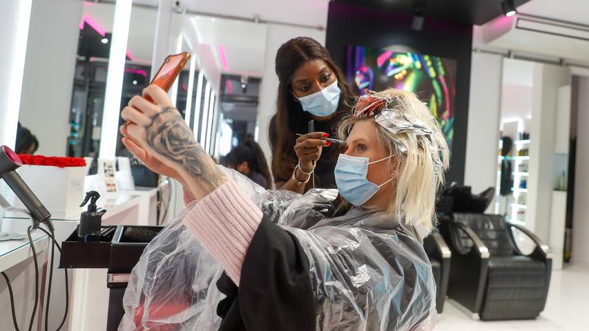 Als erster Kundin des Friseurladens Magali Coiffeur in Berlin werden Arielle Rippegather nach der Wiedereröffnung die Haare geschnitten und gefärbt. In Berlin ist der Zutritt ins Geschäft auch mit medizinischer Maske erlaubt. In Bayern dagegen dürfen Kunden nur mit FFP2-Maske ins Friseurgeschäft.