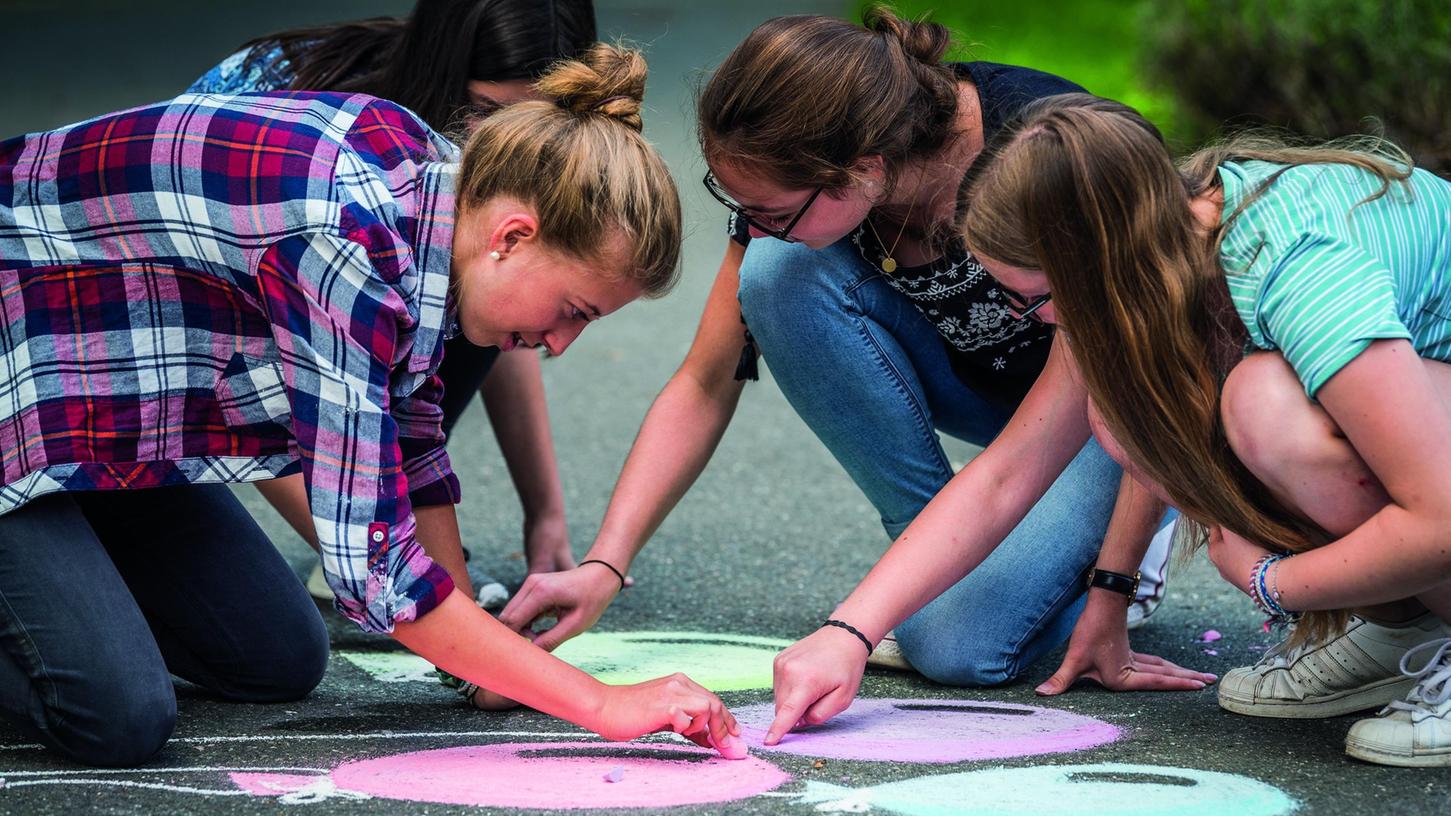 Aus einer Zeit, als es noch Freizeitprogramm für Jugendliche gab: Mädchen malen mit Straßenkreide auf der Burg Feuerstein bei Ebermannstadt.
