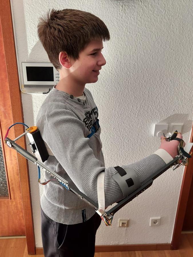 Goran Mirkov (14) steuert mit seinem echten Arm einen Controller, der die Bewegungen auf seinen Roboterarm überträgt.  