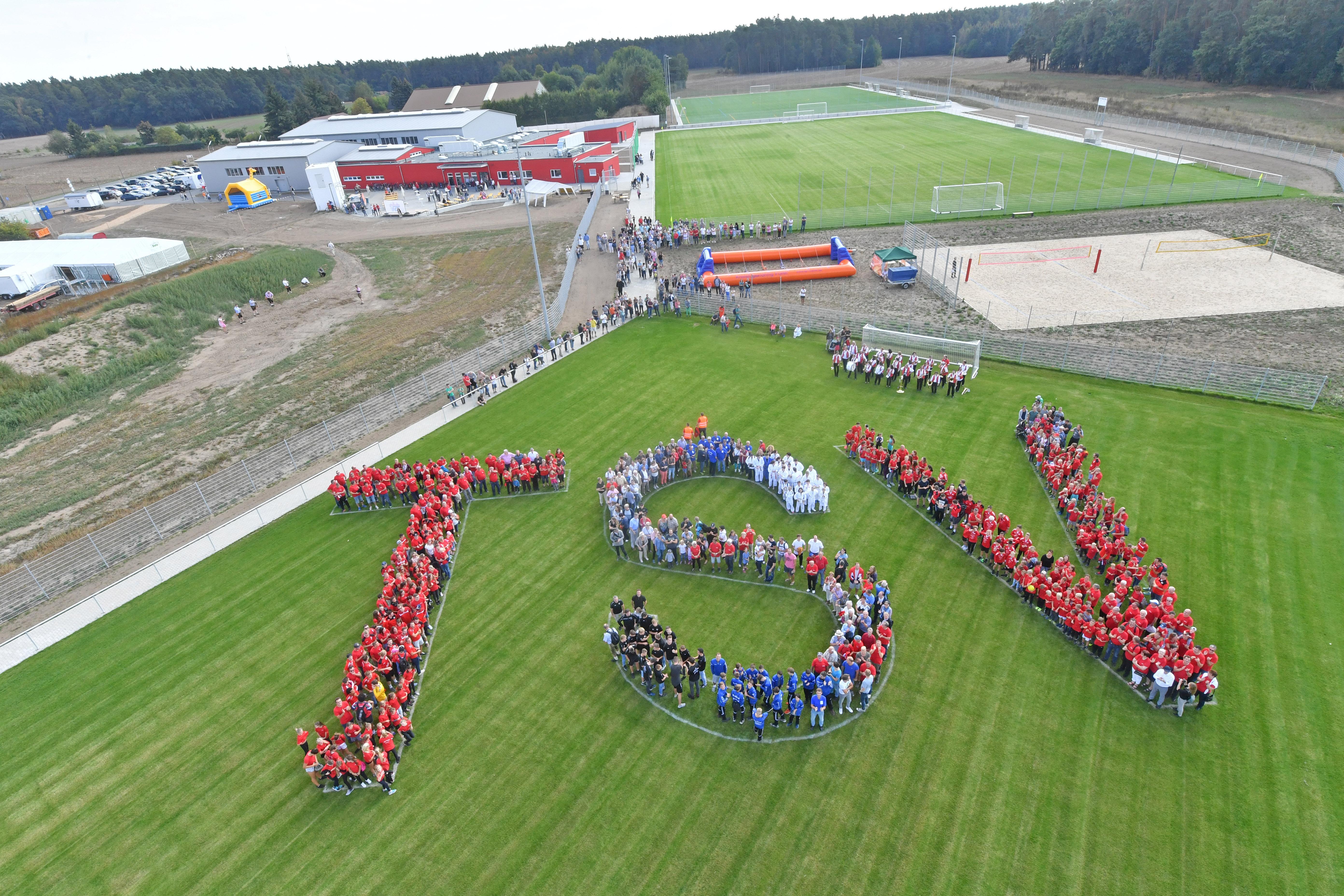 Viele Menschen formen den Schriftzug "TSV": Die beiden Roßtaler Sportvereine Tuspo und TV haben fusioniert, Die neue "Sportmeile" ist jetzt ihre Heimat.