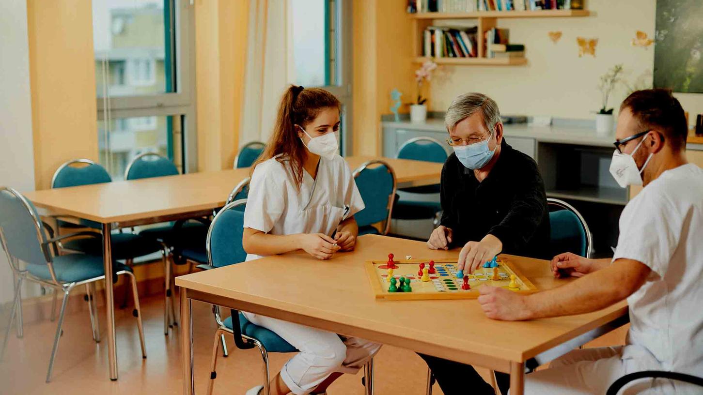 Zwei Betreuungskräfte spielen mit einem Heimbewohner Brettspiele. Foto: Jacqueline Wardeski Zwei Betreuungskräfte spielen mit einem Heimbewohner Brettspiele. Foto: Jacqueline Wardeski