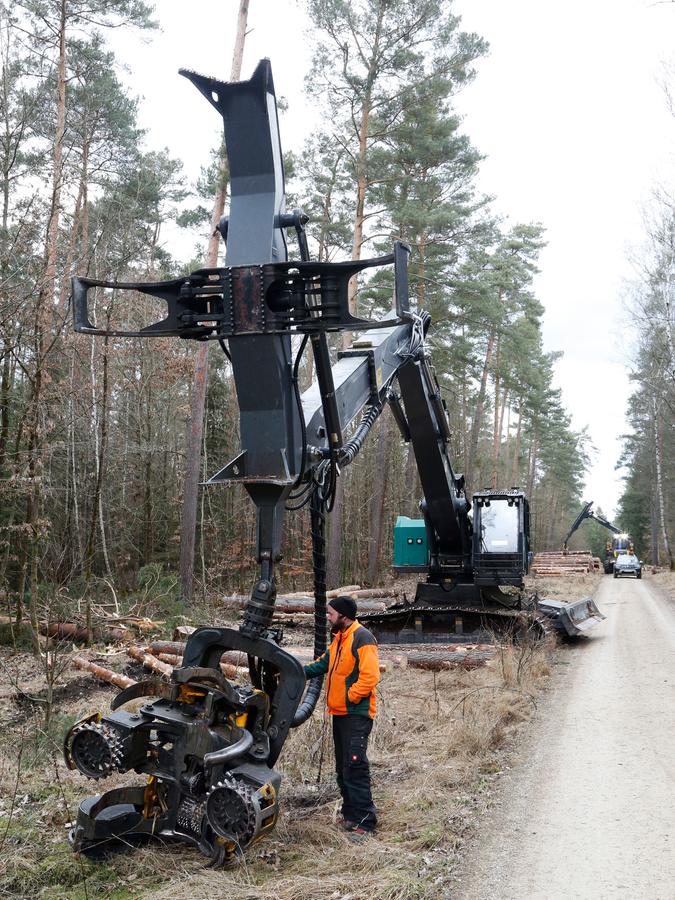 Maschinenführer Robert Frischholz zeigt die Greifarme es Baggerharvesters. 