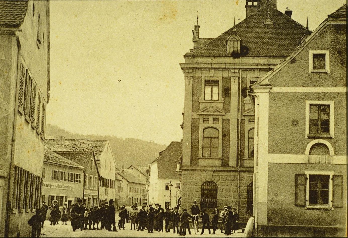 Das Treuchtlinger Rathaus (rechts) zu Beginn des 20. Jahrhunderts. Gut zu sehen sind links im Bild die einstigen Jurahäuser, die auf dem Areal des heutigen Rathausplatzes stehen.