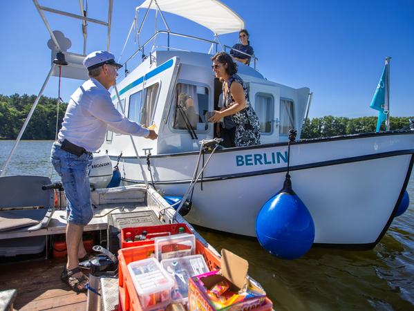Jens Winkelmann ist mit seinem Wasserkiosk auf dem Vilzsee unterwegs und verkauft geräucherte Forellen an eine Urlauberfamilie aus Darmstadt, die auf dem Hausboot "Berlin" unterwegs sind.