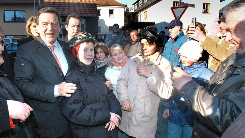 Bundeskanzler Gerhard Schröder, umringt von Fans, 2005 bei der Einweihung  des damals neuen Puma-Hauptquartiers. Als Gebäudekomplex "Vision" befindet sich die Firmenzentrale nun am Hans-Ort-Ring.   