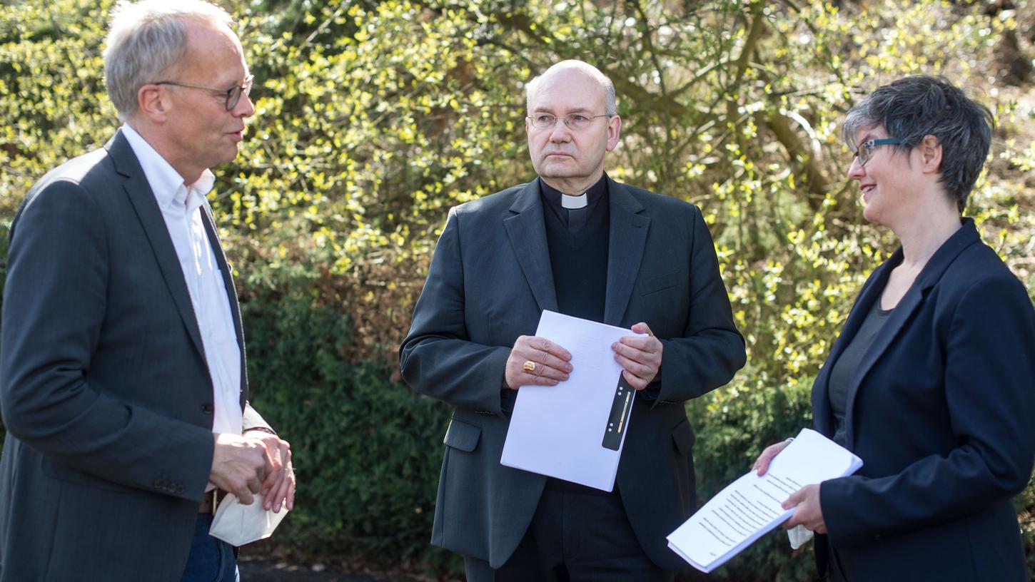 Pfarrer Burkhard Hose (l.), überreicht Bischof Helmut Dieser und Birgit Mock, Vorsitzende des Synodal-Forums "Sexualität und Partnerschaft", die Unterschriftenliste.