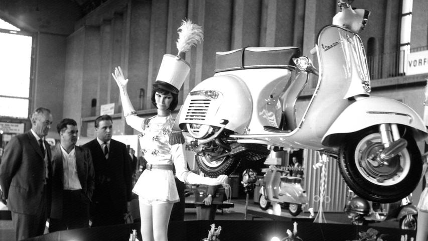 Eine Puppe trägt scheinbar mühelos mit einer Hand das neue Vespa-Modell auf der 5. Internationalen Fahrrad- und Motorradausstellung (IFMA) im September 1962 in Frankfurt am Main. Die erste Vespa kam vor 1946 Jahren in Italien auf den Markt.