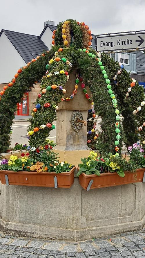Eine kleine Rumpfmannschaft des sonst großen Osterbrunnenteams fand sich zusammen und hat den Osterbrunnen bunt geschmückt. Die Blumenkästen rund um den Brunnen wurden wieder als Spende von der Gärtnerei Burmann wunderschön bepflanzt.