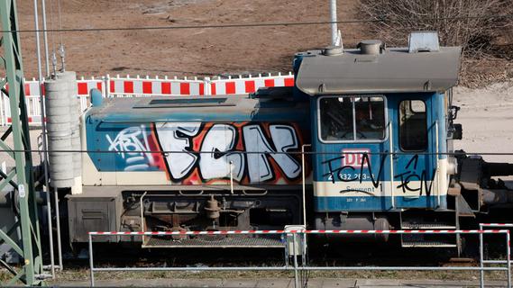 Selbst vor dem Bahngelände machen die Sprayer nicht halt: Graffiti an einer Lok und Waggons, die unter der Jansenbrücke stehen.  