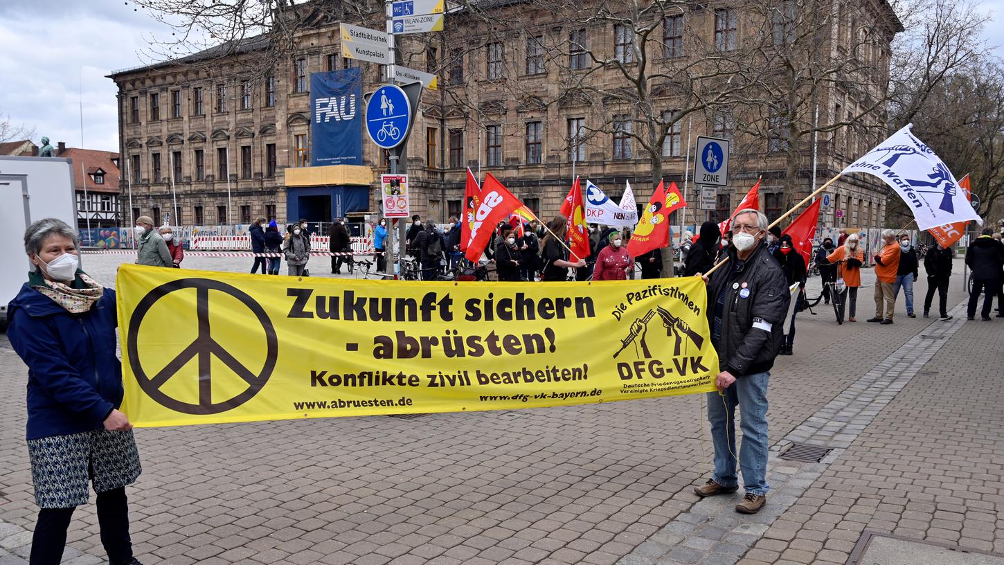 Mit Transparenten und Fahnen traten die Teilnehmer des diesjährigen Ostermarsches bei der Kundgebung auf dem Erlanger Schlossplatz für Maßnahmen zur Friedenssicherung ein und forderten ein Ende der weltweiten Aufrüstung.