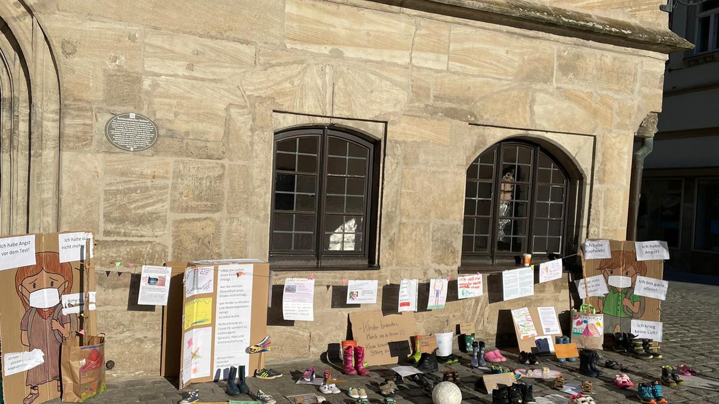 Mit Plakaten und Schuhen haben Eltern an Ostern am Gotischen Rathaus in Weißenburg für Kinderrechte in der Corona-Pandemie demonstriert. Doch wegen einiger extremer Plakate wurde die Aktion vorzeitig abgebrochen.