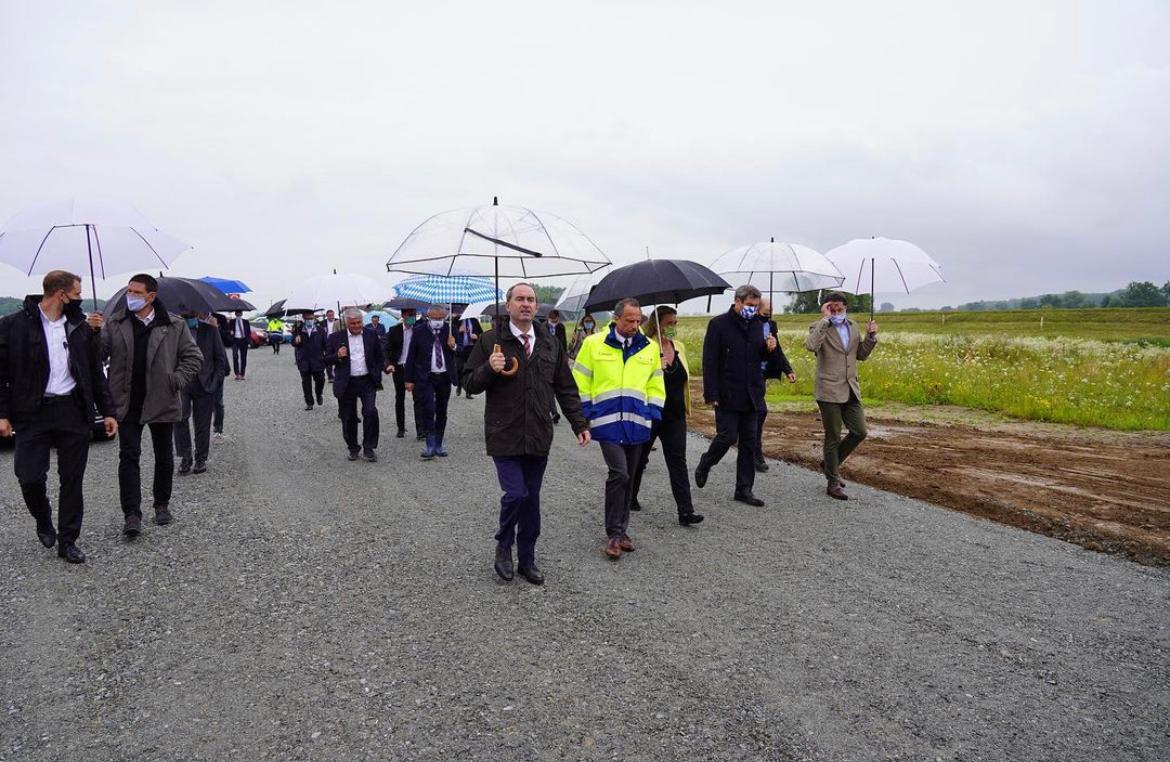 Hubert Aiwanger, ausgestattet mit modischem und nicht zu kleinem Regenschirm, auf dem Weg zum Spatenstich für den Donauausbau Straubing-Vilshofen im Juli 2020.