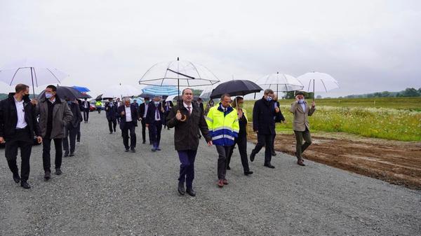 Hubert Aiwanger, ausgestattet mit modischem und nicht zu kleinem Regenschirm, auf dem Weg zum Spatenstich für den Donauausbau Straubing-Vilshofen im Juli 2020.