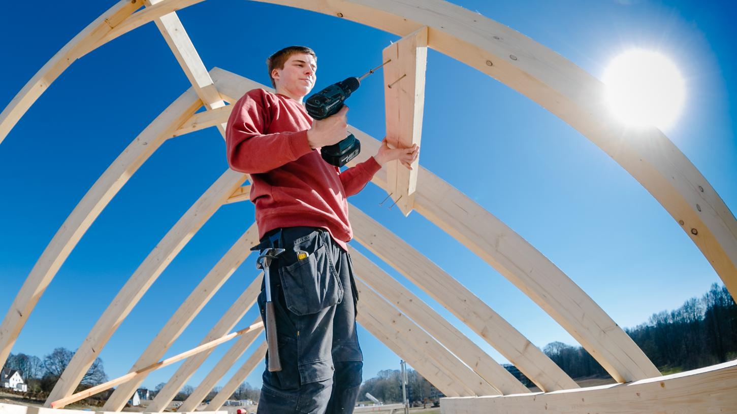 Zimmerer müssen derzeit oft lange auf ihr Holz warten. Durch die gestiegenen Preise zahlen sie momentan drauf, weil die Preise mit den Kunden beim Hausbau zuvor vertraglich festgelegt wurden. Bei künftigen Bauprojekten werden aber wohl vor allem die Häuslebauer selbst draufzahlen müssen.
Zimmerer müssen derzeit oft lange auf ihr Holz warten. Durch die gestiegenen Preise zahlen sie momentan drauf, weil die Preise mit den Kunden beim Hausbau zuvor vertraglich festgelegt wurden. Bei künftigen Bauprojekten werden aber wohl vor allem die Häuslebauer selbst draufzahlen müssen.