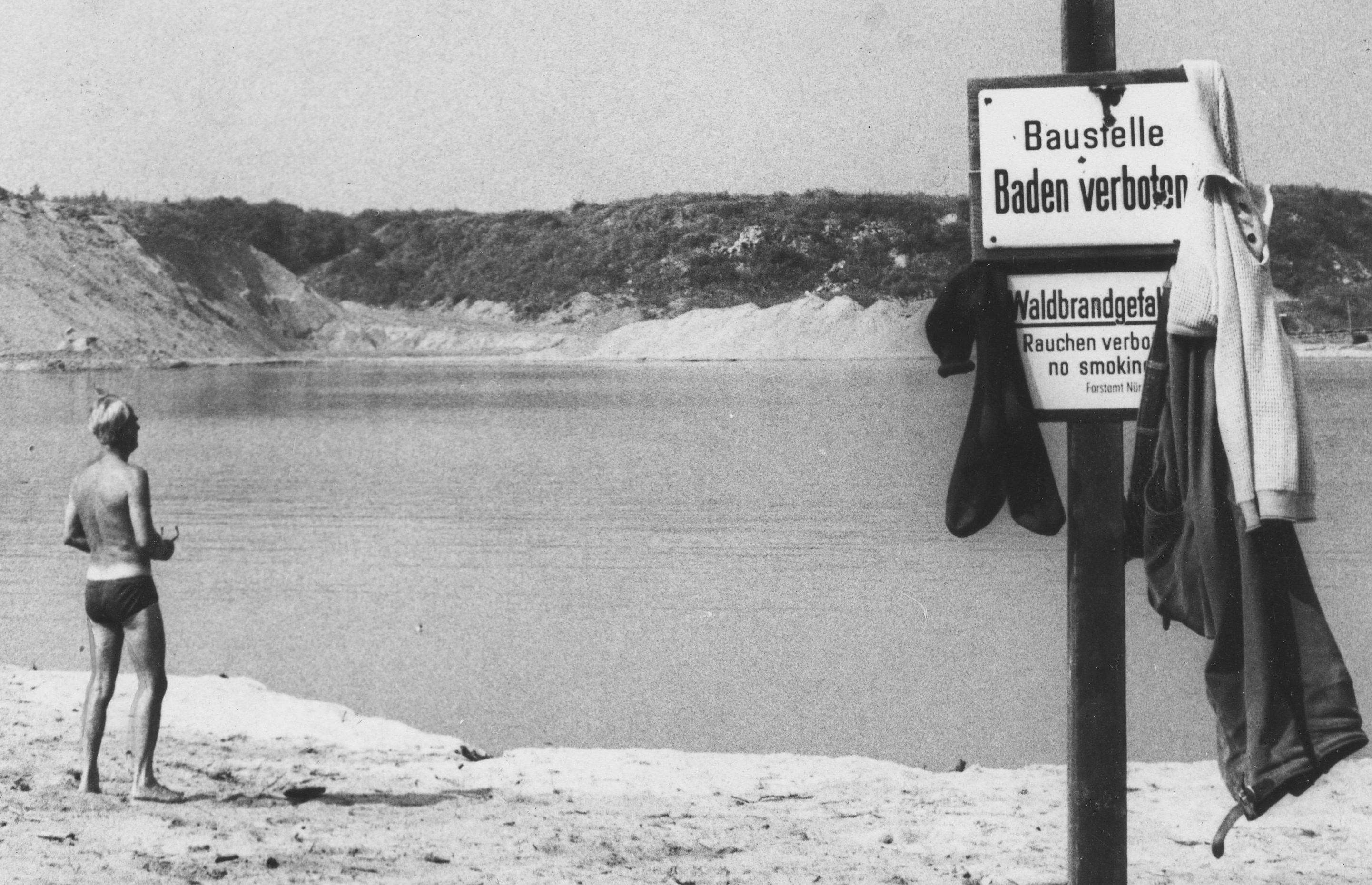 Von Verbotsschildern unbeeindruckt, genossen viele Badende aus dem Umkreis die Erfrischung im Baggersee. Die Polizei drückte ein Auge zu, wenn sie dort vorbeikam. An manchen heißen Sommer-Wochenenden kamen mehrere Hundert Besucher*innen, darunter auch viele aus Nürnberg. Diese Aufnahme stammt aus dem Jahr 1972.