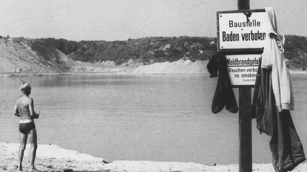 Von Verbotsschildern unbeeindruckt, genossen viele Badende aus dem Umkreis die Erfrischung im Baggersee. Die Polizei drückte ein Auge zu, wenn sie dort vorbeikam. An manchen heißen Sommer-Wochenenden kamen mehrere Hundert Besucher*innen, darunter auch viele aus Nürnberg. Diese Aufnahme stammt aus dem Jahr 1972.