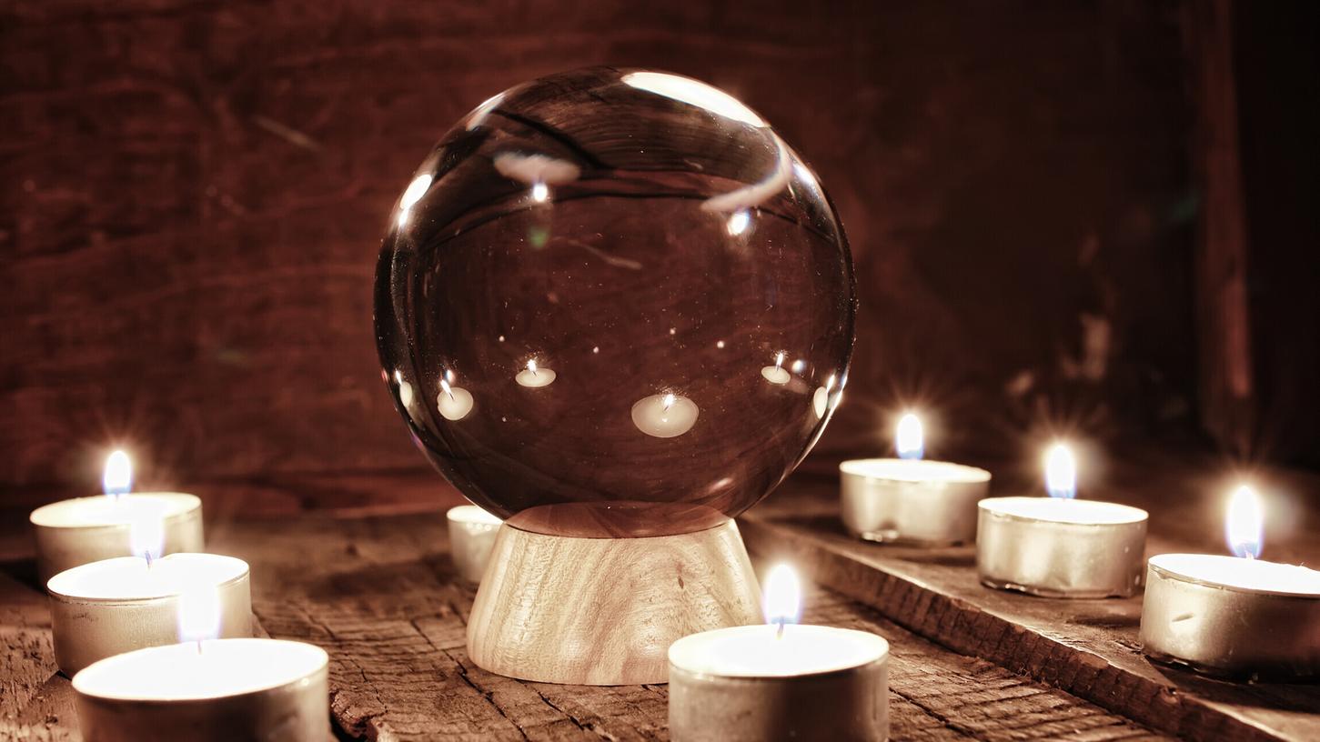 Kristallkugeln werden zur Vorhersage des Schicksals und der übernatürlichen Handlung benutzt. Auf dem Tisch liegen noch Kerzen und Karten, wichtige Mittel einer Wahrsagerin. 