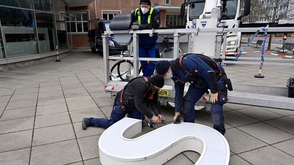 Bereits im Dezember wurden die Schlüssel zum Erlanger „Himbeerpalast“ von der Siemens AG an die FAU übergeben – nun hat die Universität das Gebäude ganz offiziell übernommen. Um die Übergabe auch nach außen hin sichtbar zu markieren, wurde während des Termins symbolisch der erste Buchstabe des Siemens-Schriftzugs vom Gebäude entfernt – in Zukunft ist dann Platz für das FAU-Logo.