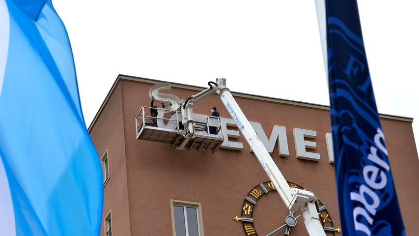 Bereits im Dezember wurden die Schlüssel zum Erlanger „Himbeerpalast“ von der Siemens AG an die FAU übergeben – nun hat die Universität das Gebäude ganz offiziell übernommen. Um die Übergabe auch nach außen hin sichtbar zu markieren, wurde während des Termins symbolisch der erste Buchstabe des Siemens-Schriftzugs vom Gebäude entfernt – in Zukunft ist dann Platz für das FAU-Logo.
