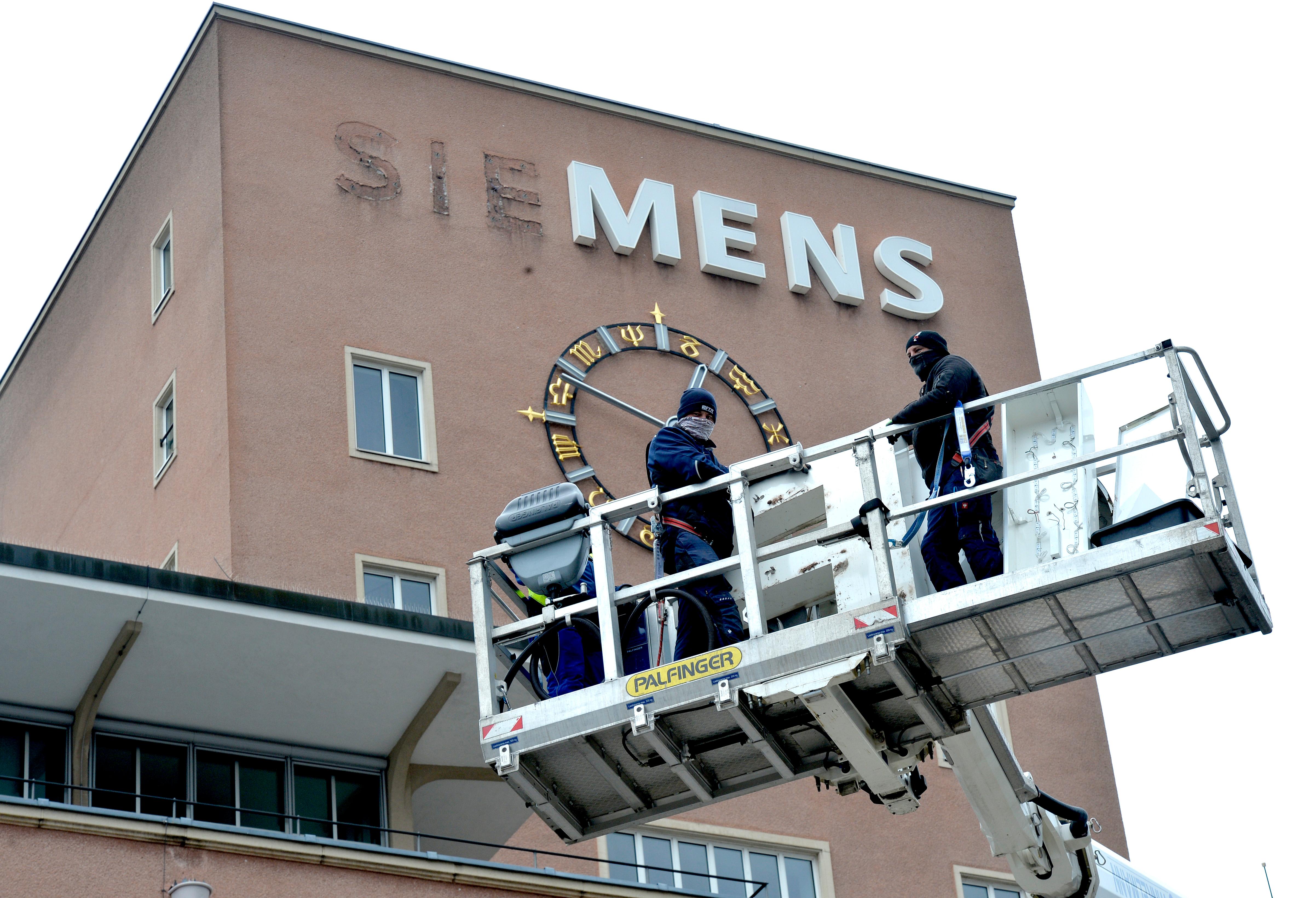 Bereits im Dezember wurden die Schlüssel zum Erlanger „Himbeerpalast“ von der Siemens AG an die FAU übergeben – nun hat die Universität das Gebäude ganz offiziell übernommen. Um die Übergabe auch nach außen hin sichtbar zu markieren, wurde während des Termins symbolisch der erste Buchstabe des Siemens-Schriftzugs vom Gebäude entfernt – in Zukunft ist dann Platz für das FAU-Logo.