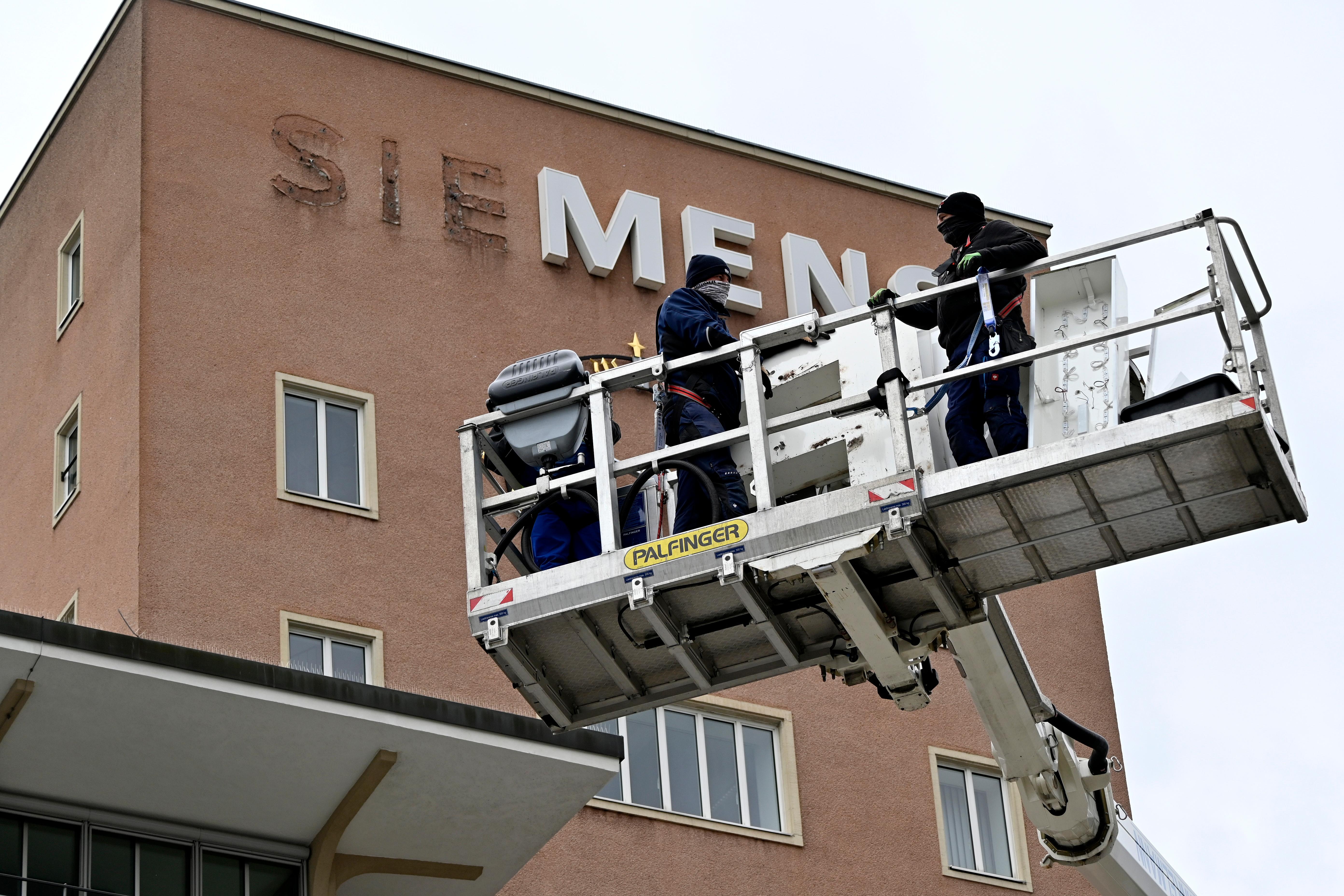 Bereits im Dezember wurden die Schlüssel zum Erlanger „Himbeerpalast“ von der Siemens AG an die FAU übergeben – nun hat die Universität das Gebäude ganz offiziell übernommen. Um die Übergabe auch nach außen hin sichtbar zu markieren, wurde während des Termins symbolisch der erste Buchstabe des Siemens-Schriftzugs vom Gebäude entfernt – in Zukunft ist dann Platz für das FAU-Logo.