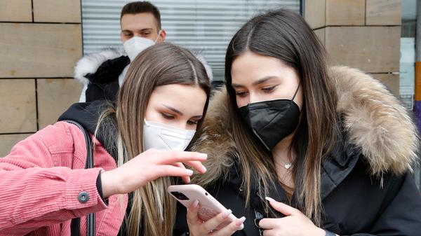 Mithilfe ihrer Handys warfen sie einen Blick auf die "Royal Donuts"-Homepage und überlegten, für welches Gebäck sie sich entscheiden sollen.