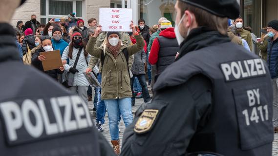 Eine Frau hält Polizisten ein Schild mit der Aufschrift "Wir sind das Volk" entgegen. Ursprünglich war eine Demonstration mit 8000 Teilnehmern in Kempten angemeldet worden.