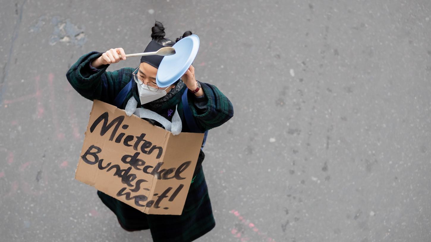 Eine Frau klopft in Berlin mit einem Löffel bei einer Demonstration des Bündnisses "Gemeinsam gegen Verdrängung und #Mietenwahnsinn" gegen das Urteil des Bundesverfassungsgerichts zum Mietendeckel auf einen Kochtopfdeckel. 