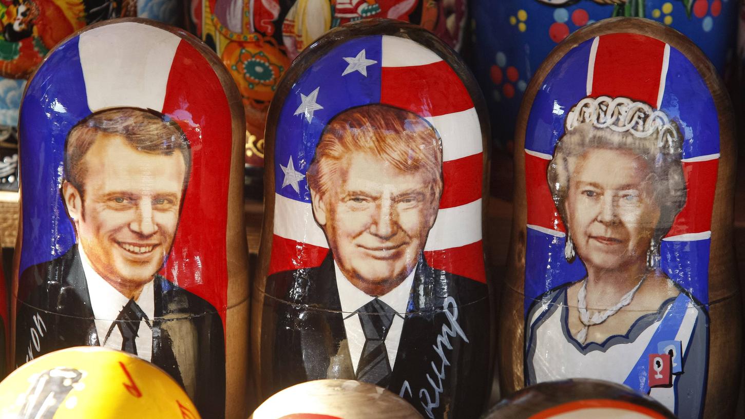 Gemalte Matrjoschkapuppen mit Porträts des französischen Präsidenten Emmanuel Macron, des US-Präsidenten Donald Trump und der britischen Königin Elizabeth II