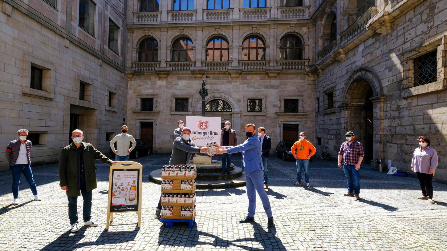 Prosit ohne einen Tropfen für die durstige Kehle - und das am Tag des Bieres: Im Innenhof des Nürnberger Rathauses stellen die beteiligten Brauer das frische "Zusammen Halbe" Nürnbergs Oberbürgermeister Marcus König vor.