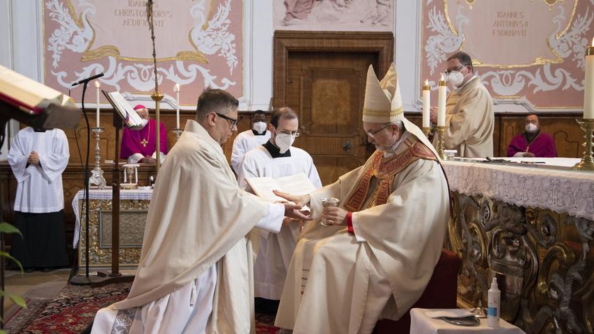 Bischof Gregor Maria Hanke salbt die Hände von Michael Krämer mit Öl.