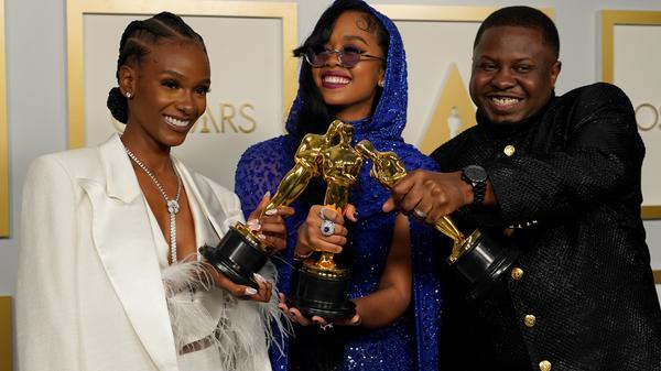 Sängerin Tiara Thomas (l-r), Sängerin H.E.R. und Musikproduzent Dernst Emile II, mit dem Oscar für den besten Originalsong für "Fight For You" aus "Judas and the Black Messiah"