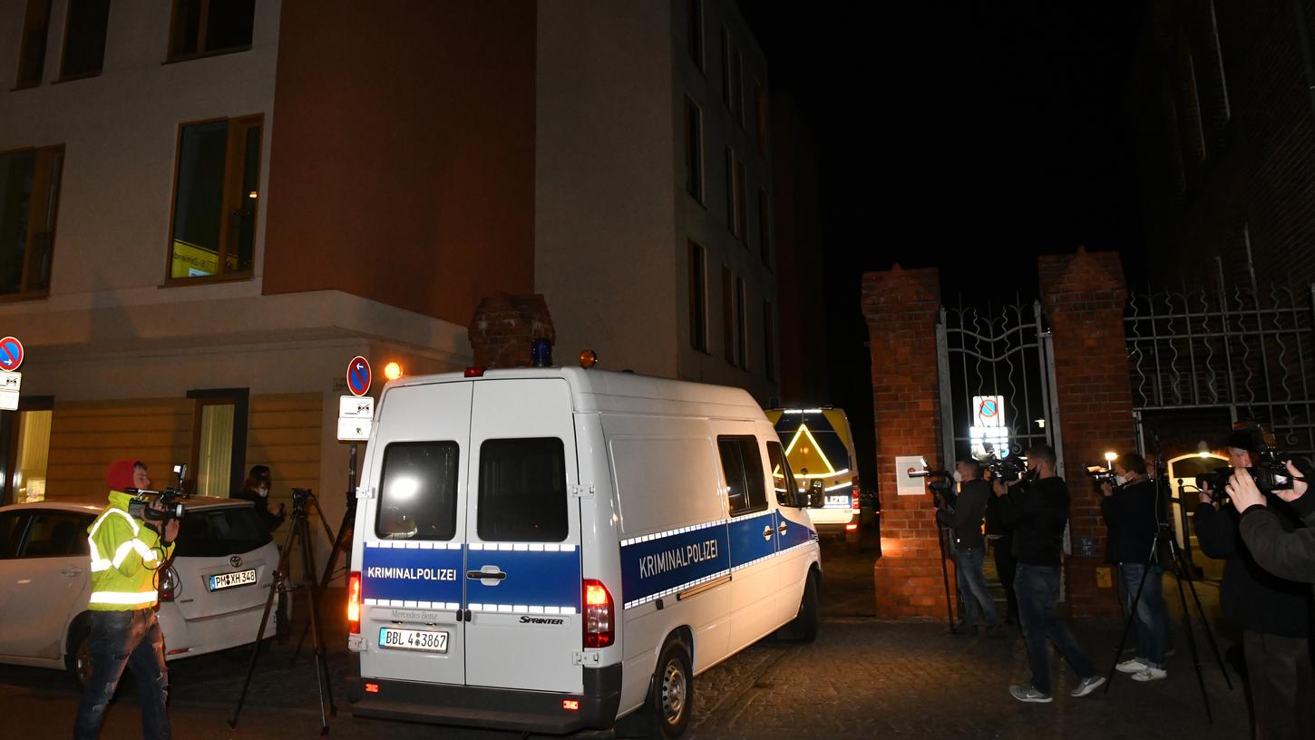 Das Einsatzfahrzeug der Kriminaltechnik der Polizei fährt an Journalisten vorbei auf ein Klinikgrundstück in Potsdam.