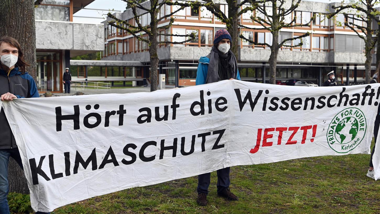 Mitglieder der Karlsruher Gruppe von Fridays for Future halten vor dem Bundesverfassungsgericht ein Transparent auf dem steht ·Hört auf die Wissenschaft! Klimaschutz jetzt!·
