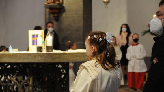 Nur das Erstkommunionkind trägt gerade keinen Mund-Nasen-Schutz, der für den Empfang der Hostie hinderlich wäre – Szene aus St. Johannes in Neumarkt.  
