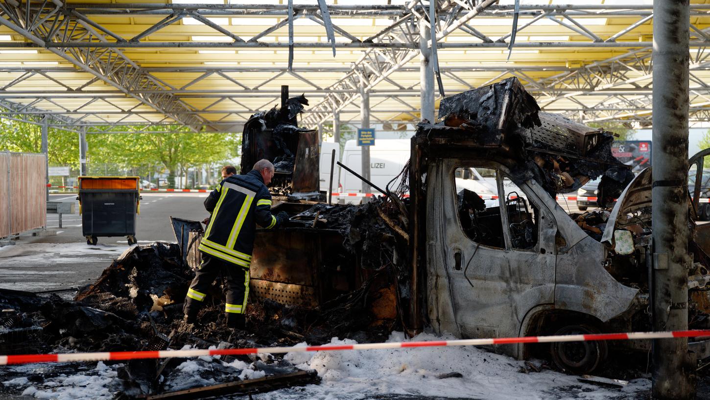 Ein Brandermittler der Polizei untersucht die Überreste des abgebrannten Reibekuchenwagens