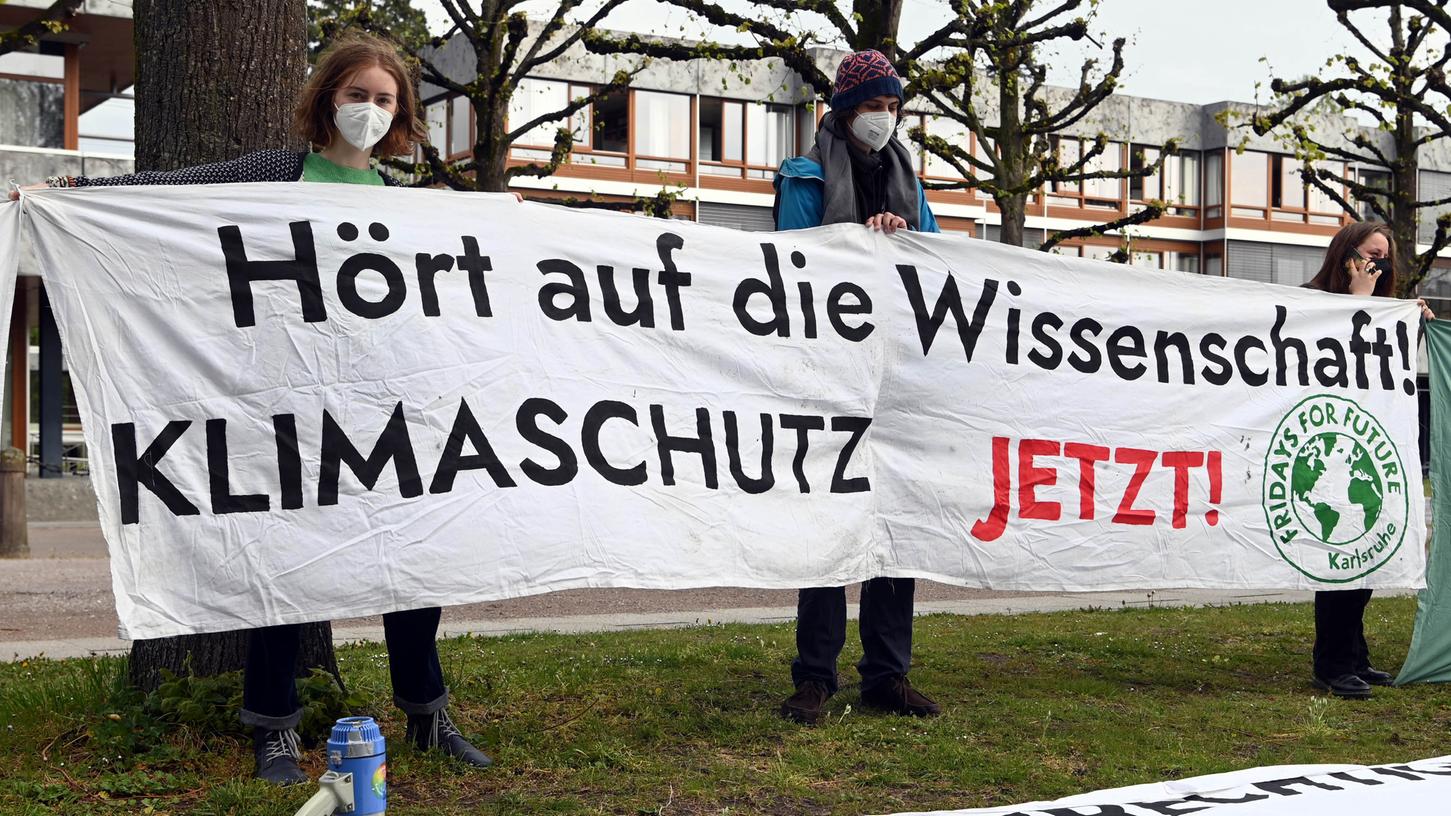 Mitglieder der Karlsruher Gruppe von "Fridays for Future" halten vor dem Bundesverfassungsgericht ein Transparent hoch - "Hört auf die Wissenschaft - Klimaschutz jetzt" wird gefordert.