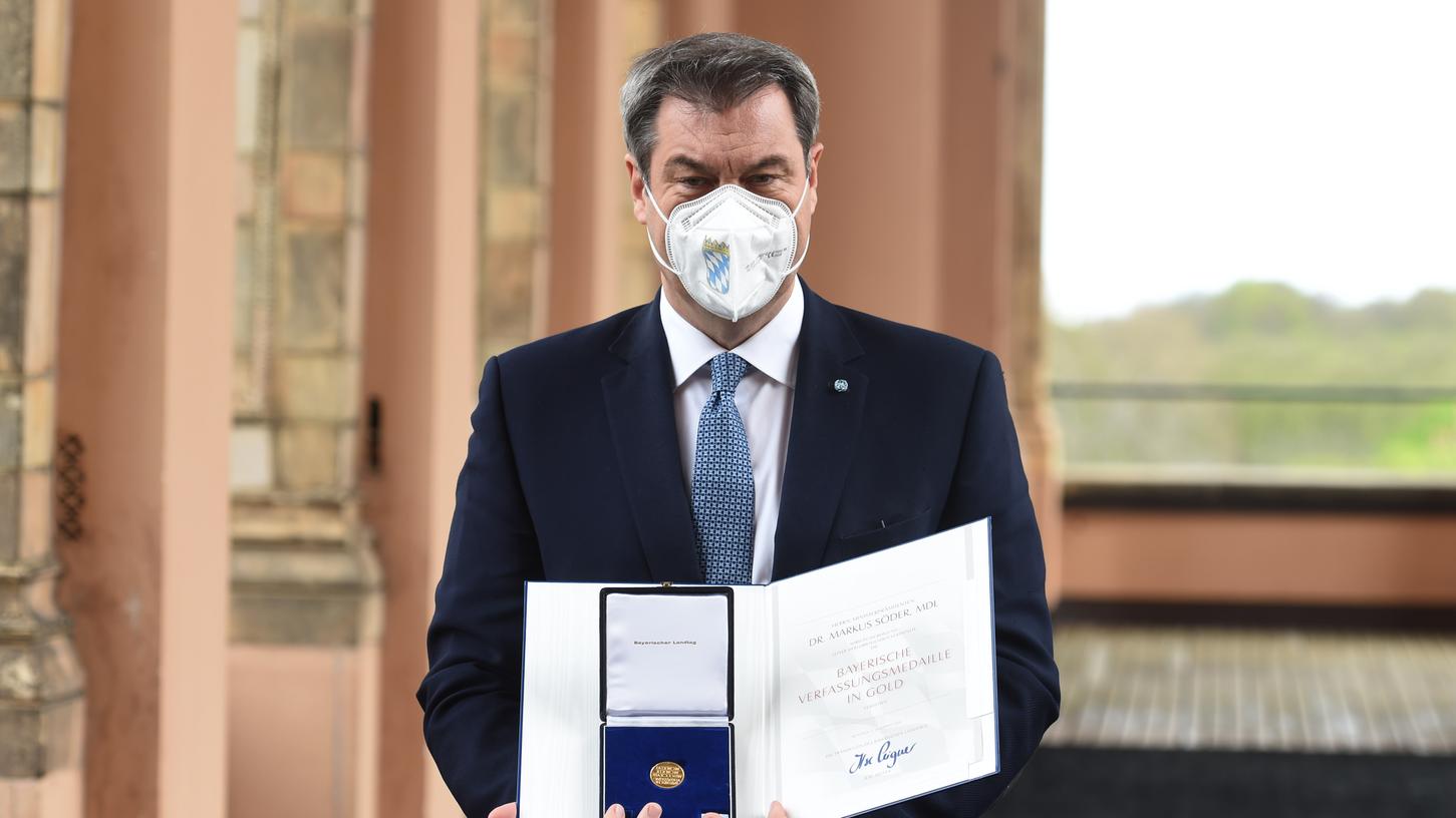 Stolz zeigt Regierungschef Markus Söder seine Auszeichnung.
Stolz zeigt Regierungschef Markus Söder seine Auszeichnung.