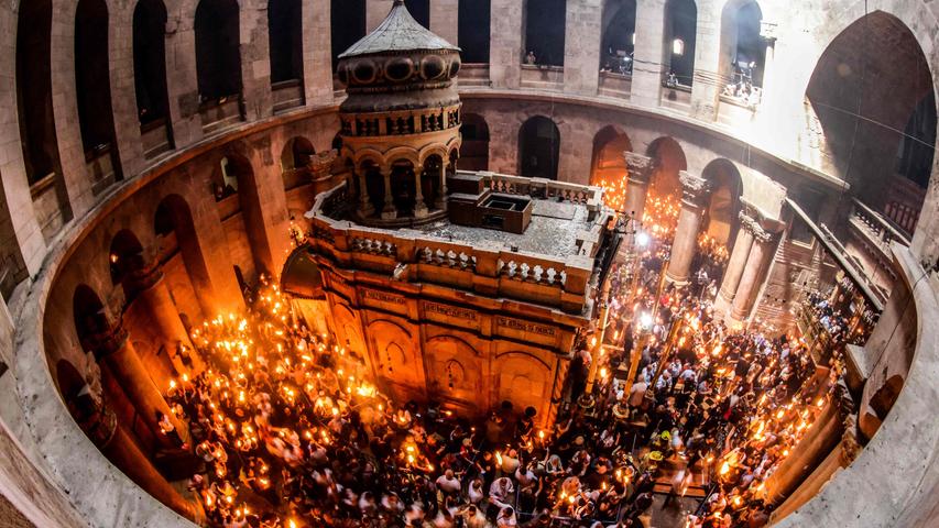 Rund um die Heilig-Grad-Ädikula, die sich im Zentrum der konstantinischen Rotunde der berühmten Grabeskirche in Jerusalem befindet, zünden orthodoxe Christen vergangenen Sonntag Kerzen an. Sie feiern Ostern. 