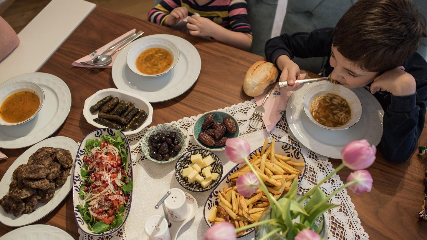 Kinder und Eltern nehmen während des heiligen Fastenmonats Ramadan ein gemeinsames Iftar-(Fastenbrechen-)Essen in ihrer Wohnung ein. 