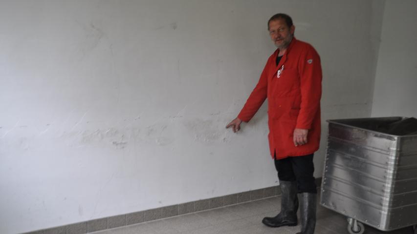 Hausmeister Hannes Tohol zeigt die Schäden an einer feuchten Wand.