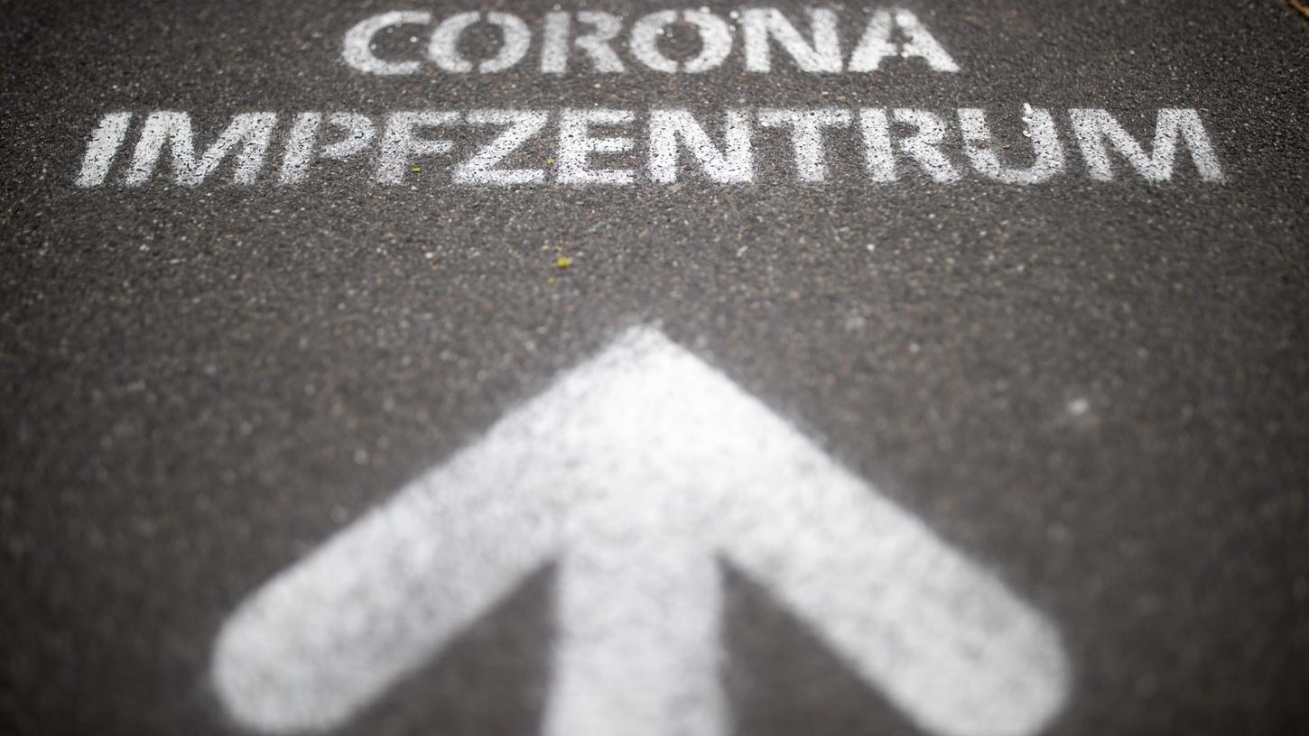 Der auf den Boden aufgesprühte Schriftzug «Corona Impfzentrum» weist den Weg auf dem Messegelände in Nürnberg.