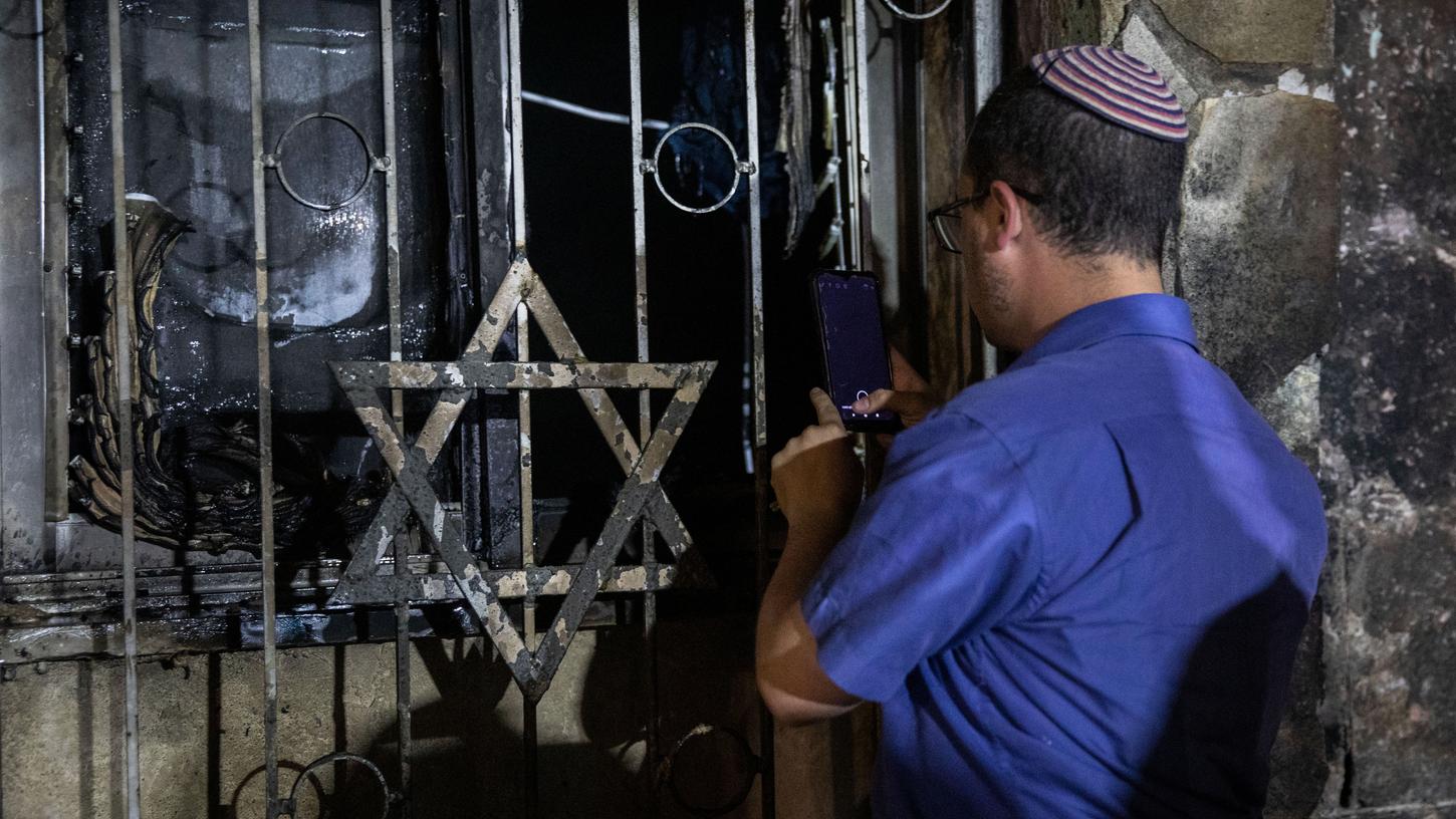 Ein israelischer Mann schaut in eine Synagoge, nachdem diese bei Zusammenstößen zwischen Juden und Arabern inmitten gewalttätiger Unruhen in der gemischt israelisch-arabischen Stadt Lod in Brand gesetzt wurde.