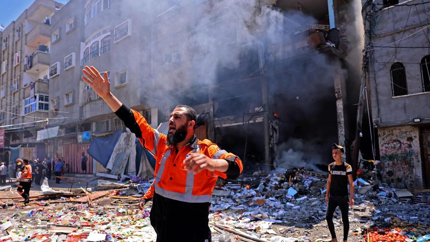 Ein palästinensischer Feuerwehrmann dirigiert seine Kollegen nach einem israelischen Raketenangriff im Gaza-Streifen. Viele Menschen starben dort, nachdem die Gewalt eskalierte. Mehr dazu lesen Sie hier.